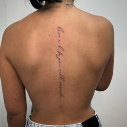 Schriftzug entlang der Wirbelsäule – Tattoo aus Köln