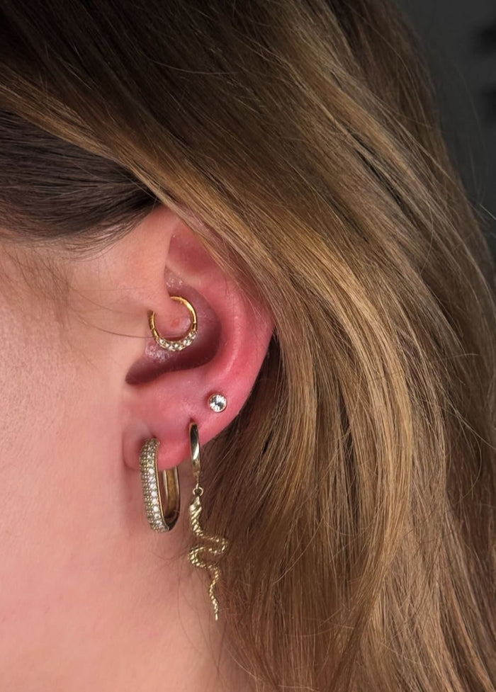Daith-Piercing mit goldenem Clicker-Ring am Ohr