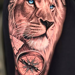 Löwe mit Kompass am Oberarm – Tattoo aus Köln