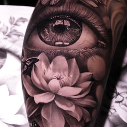 Auge mit Blüten am Unterarm – Tattoo aus Köln